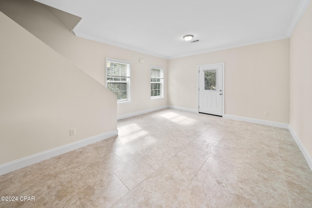 spare room with light tile patterned floors and crown molding