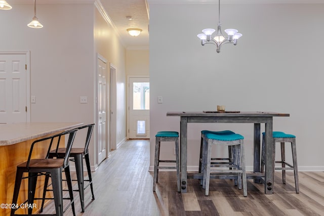 kitchen featuring appliances with stainless steel finishes, hanging light fixtures, sink, kitchen peninsula, and light hardwood / wood-style flooring