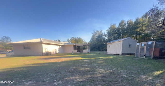 view of yard with central AC unit and a shed