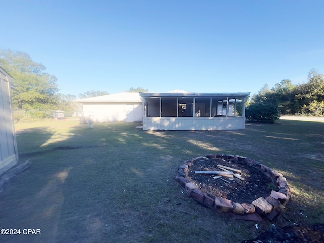 back of property with a lawn and a sunroom