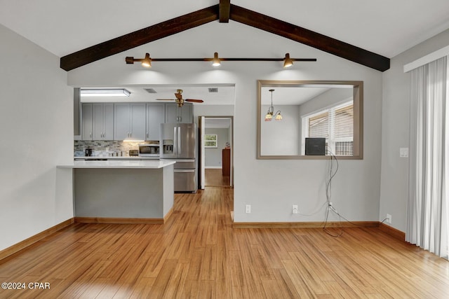 kitchen featuring gray cabinets, appliances with stainless steel finishes, vaulted ceiling with beams, tasteful backsplash, and kitchen peninsula