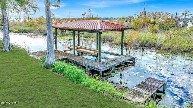 dock area with a water view and a yard