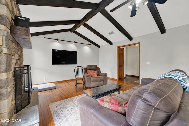 living room with lofted ceiling with beams, ceiling fan, a fireplace, and light hardwood / wood-style flooring