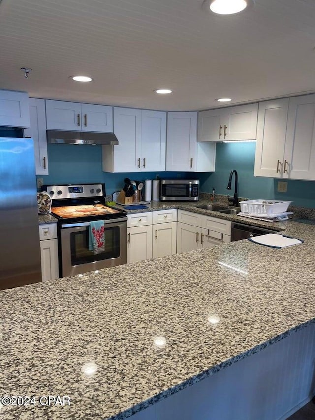 kitchen featuring white cabinets, stainless steel appliances, stone counters, and sink