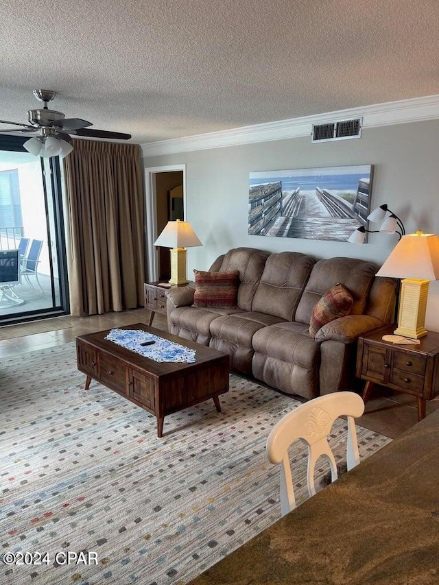 living room with a textured ceiling, ceiling fan, and crown molding