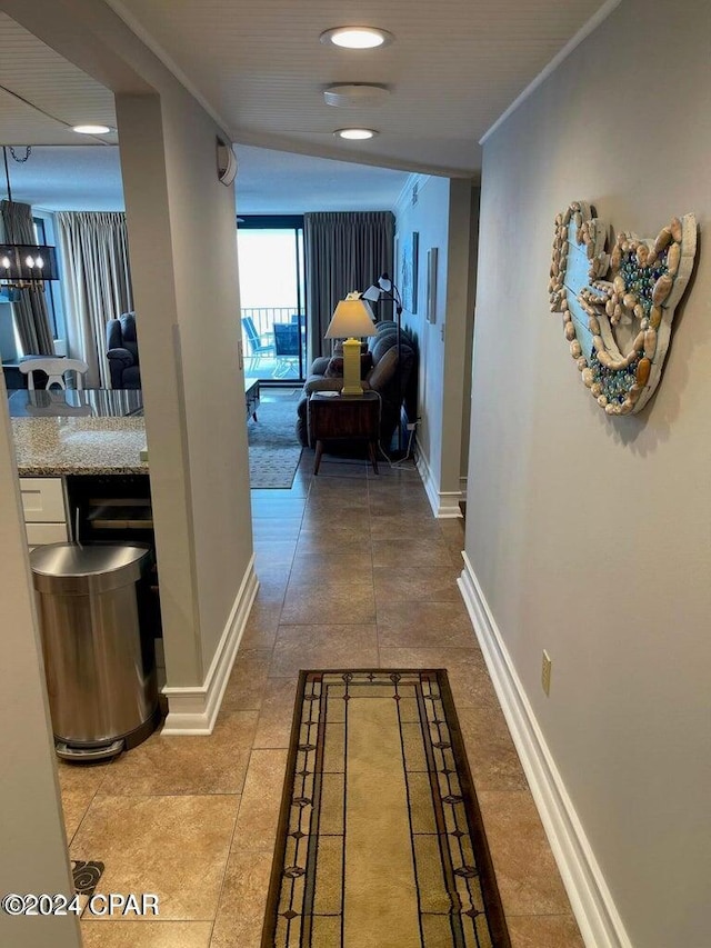 hallway featuring ornamental molding and an inviting chandelier