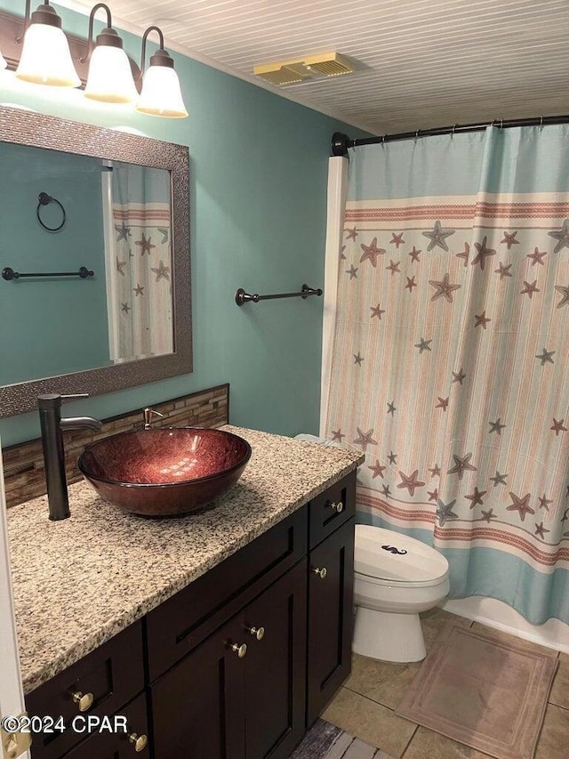 bathroom with tile patterned flooring, vanity, and toilet