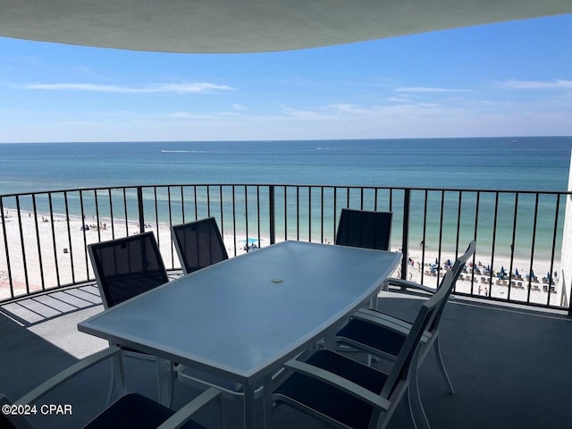 balcony with a water view and a view of the beach