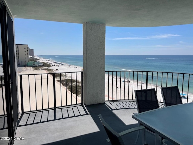 balcony featuring a beach view and a water view