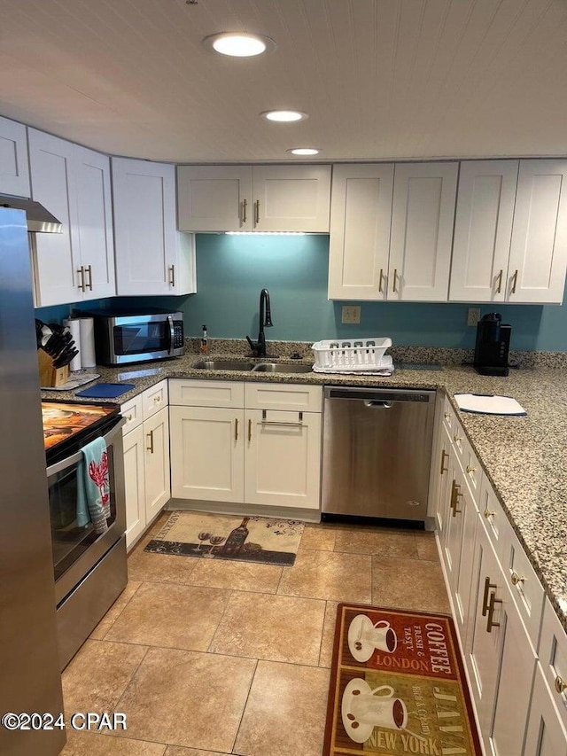 kitchen featuring white cabinets, sink, light stone countertops, and stainless steel appliances