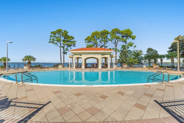 view of pool with a patio and a water view