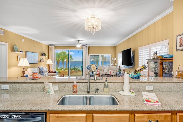 kitchen with a healthy amount of sunlight, sink, light stone counters, and ornamental molding