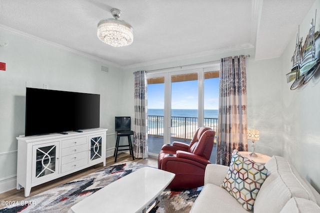 living room with ornamental molding, hardwood / wood-style flooring, and a notable chandelier