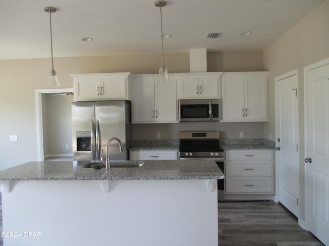 kitchen featuring light stone counters, stainless steel appliances, decorative light fixtures, sink, and white cabinets