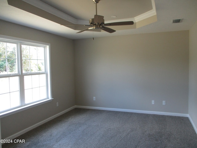 carpeted empty room with ornamental molding, ceiling fan, and a raised ceiling