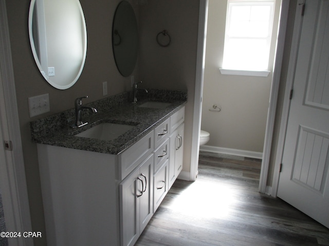 bathroom with toilet, vanity, and hardwood / wood-style flooring