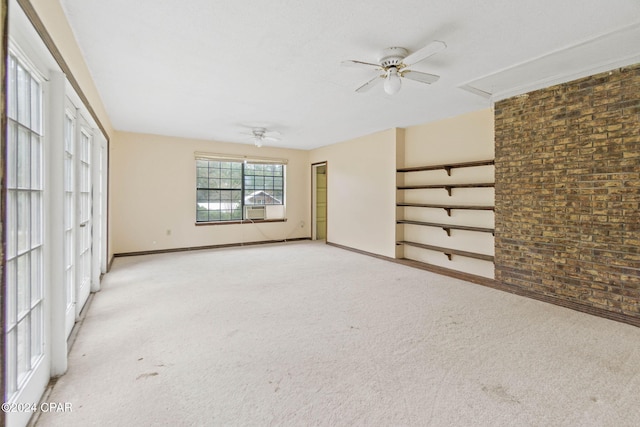 unfurnished living room with ceiling fan, brick wall, light carpet, and cooling unit