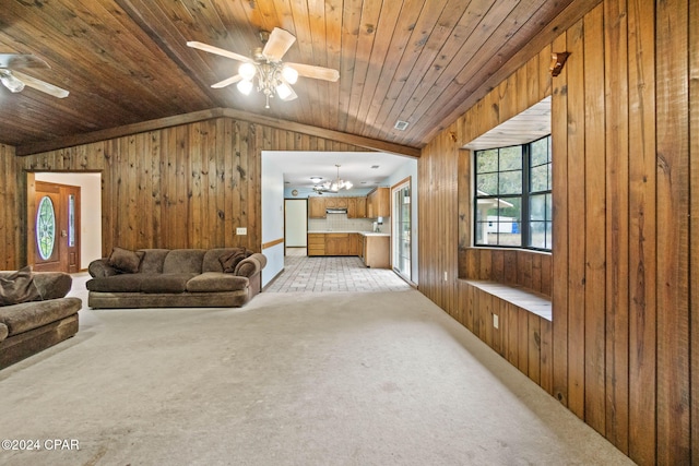 carpeted living room featuring wood walls, wood ceiling, and ceiling fan with notable chandelier