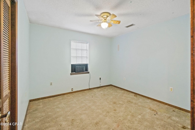 carpeted spare room featuring ceiling fan, a textured ceiling, and cooling unit