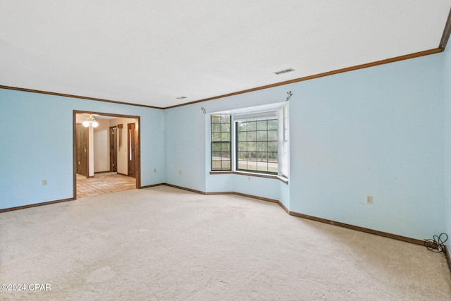 spare room featuring ornamental molding, light colored carpet, and ceiling fan