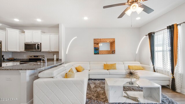 living room featuring ceiling fan and light hardwood / wood-style flooring