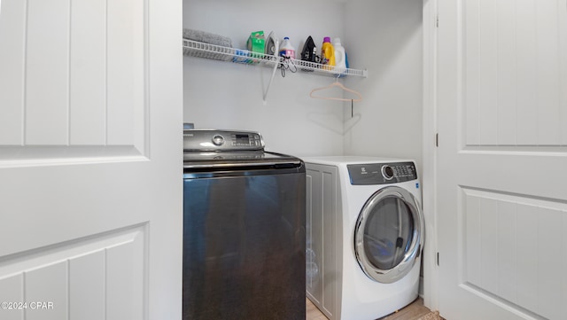 washroom with light wood-type flooring and independent washer and dryer