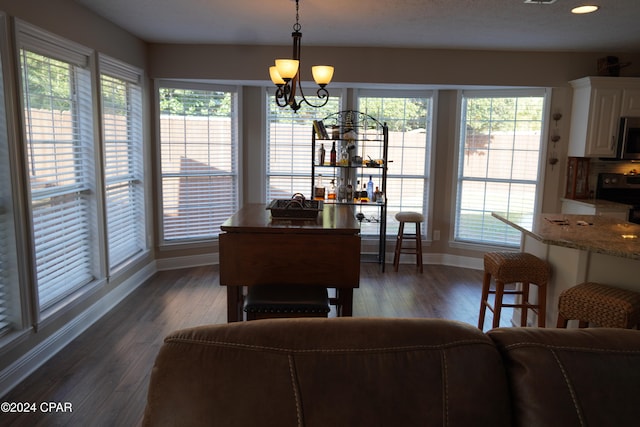 dining space featuring dark hardwood / wood-style floors and an inviting chandelier