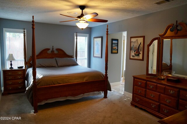 carpeted bedroom with a textured ceiling and ceiling fan