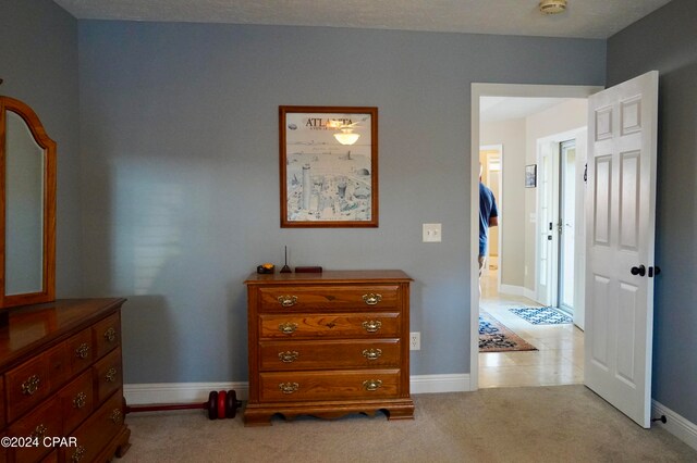 bedroom featuring a textured ceiling and light colored carpet