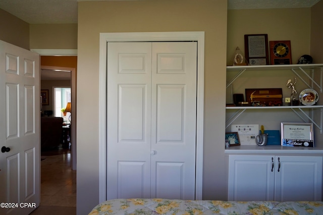 tiled bedroom featuring a textured ceiling and a closet