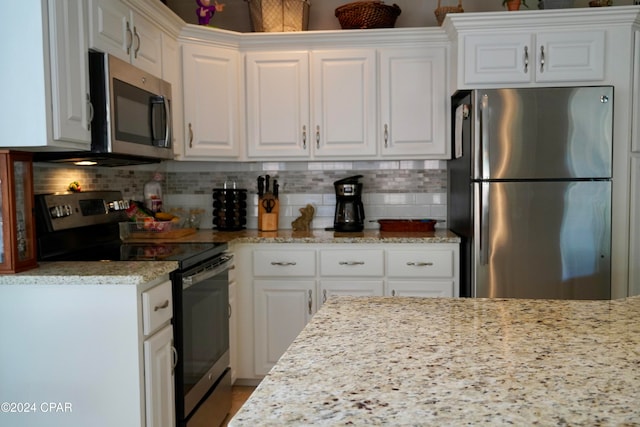 kitchen featuring white cabinetry, appliances with stainless steel finishes, light stone counters, and tasteful backsplash