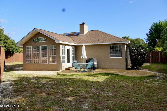 back of property featuring a yard and a patio