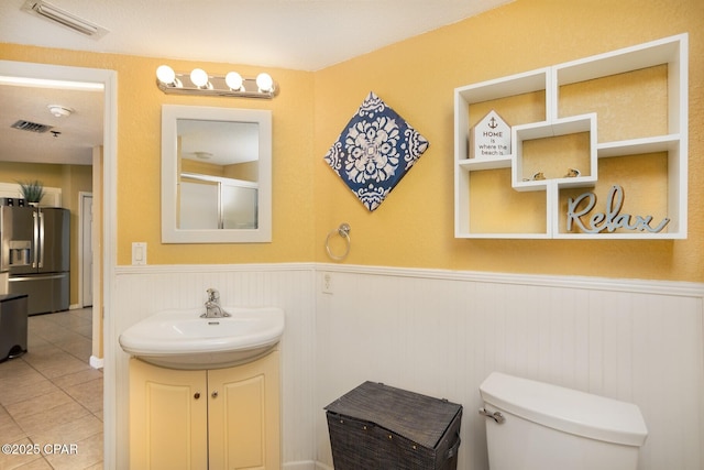 bathroom featuring walk in shower, tile patterned floors, toilet, and vanity