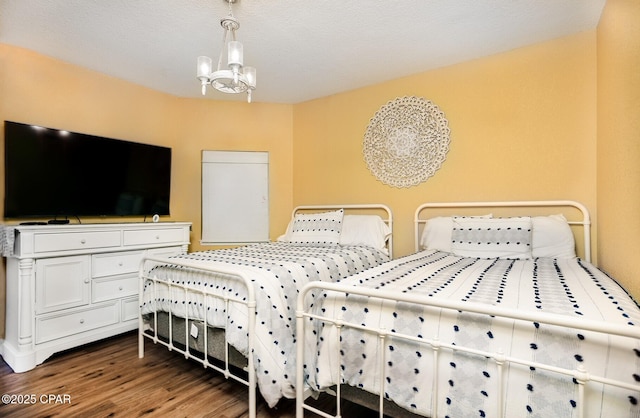 bedroom featuring an inviting chandelier and dark hardwood / wood-style flooring