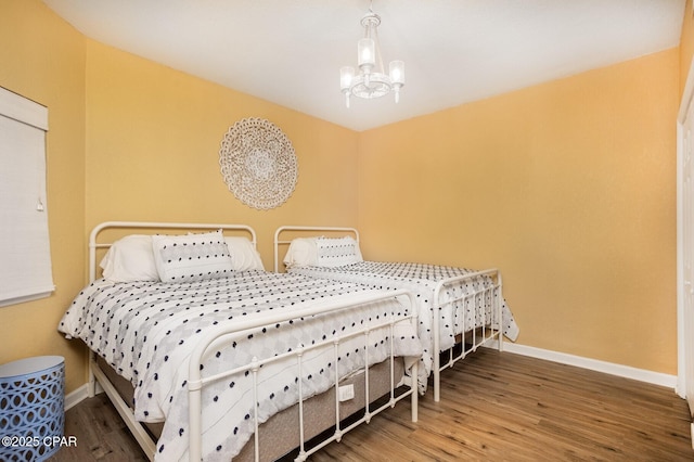 bedroom featuring dark hardwood / wood-style flooring and an inviting chandelier