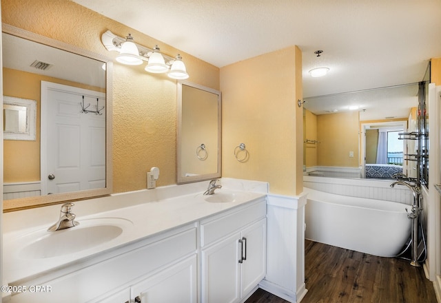 bathroom with vanity, a bathtub, and hardwood / wood-style floors