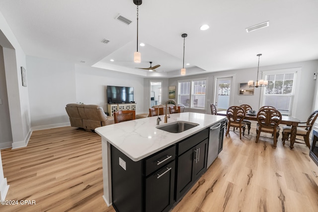 kitchen with a center island with sink, plenty of natural light, sink, and stainless steel dishwasher