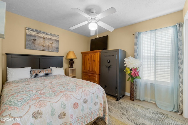 bedroom with ceiling fan and a textured ceiling