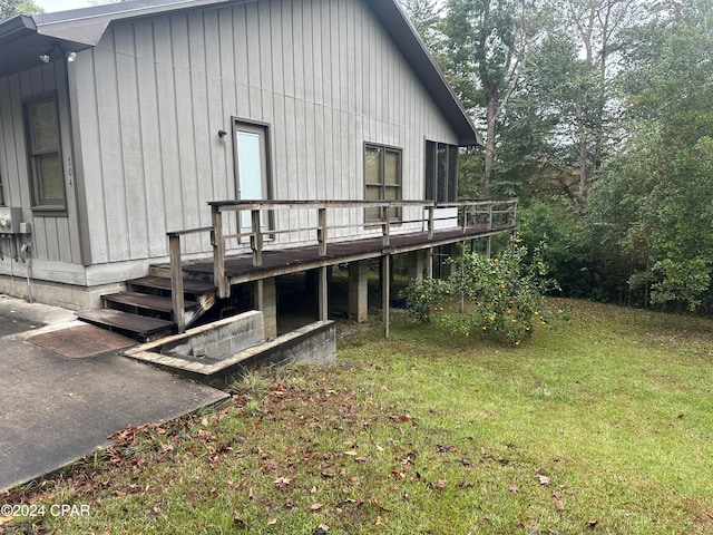 rear view of property with a wooden deck and a yard