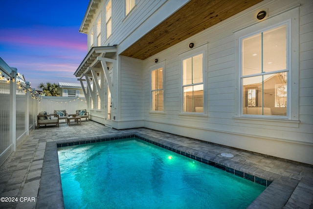 pool at dusk with a patio