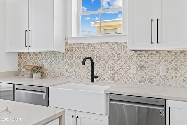 kitchen featuring white cabinetry, sink, light stone counters, and stainless steel dishwasher