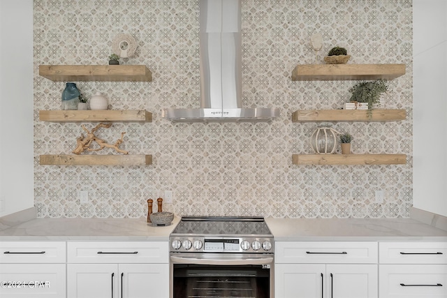 kitchen with white cabinetry, wall chimney range hood, electric range, and light stone counters