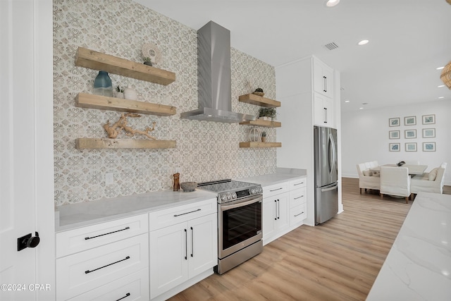 kitchen with wall chimney exhaust hood, white cabinetry, appliances with stainless steel finishes, and light stone countertops