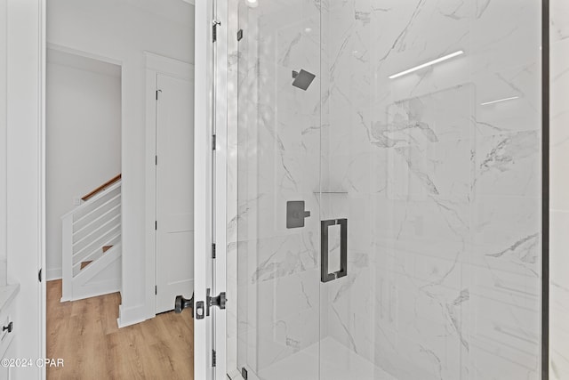 bathroom featuring hardwood / wood-style flooring and a shower with shower door