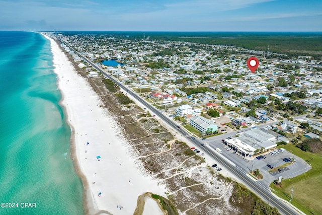 birds eye view of property with a water view and a beach view