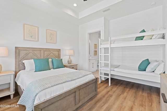 bedroom featuring connected bathroom and light hardwood / wood-style floors