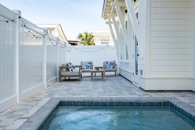 view of pool with an outdoor living space and a patio