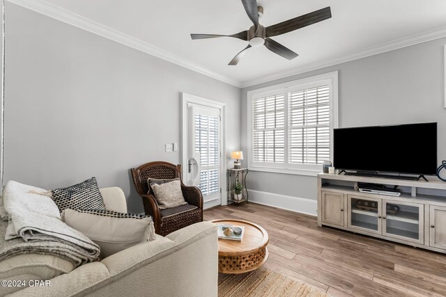 living area with light wood finished floors, crown molding, baseboards, and ceiling fan