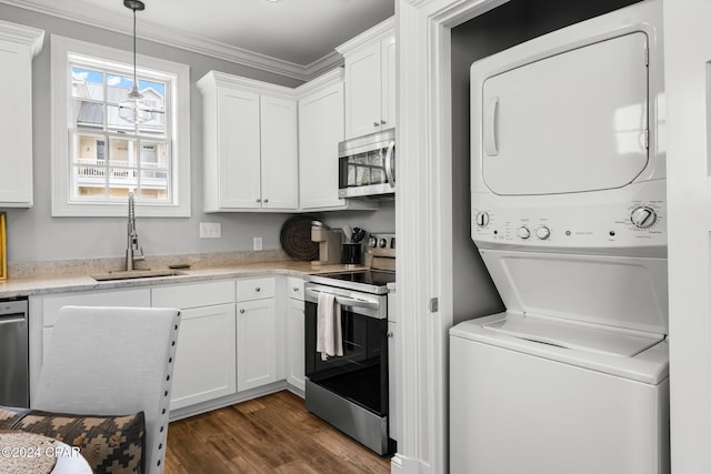 laundry area featuring a sink, dark wood-type flooring, ornamental molding, stacked washer and dryer, and laundry area