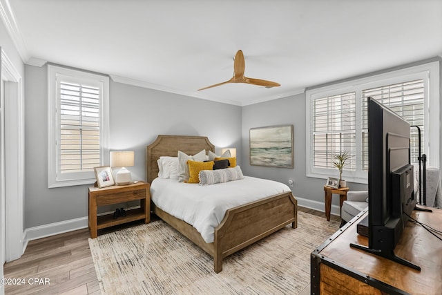 bedroom with a ceiling fan, baseboards, light wood-style floors, and crown molding
